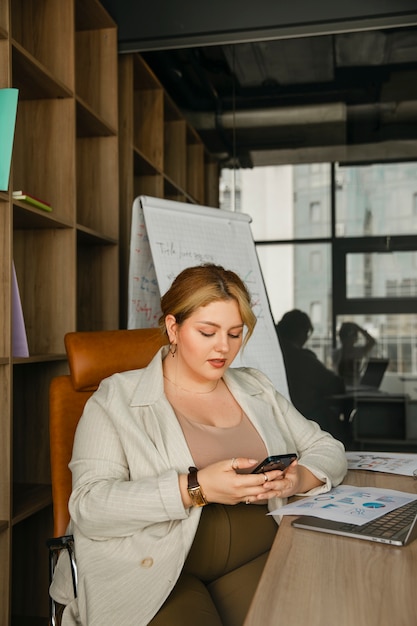 Foto gratuita donna taglie forti che lavora in un ufficio professionale