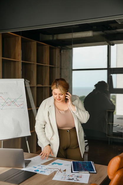 Foto gratuita donna taglie forti che lavora in un ufficio professionale