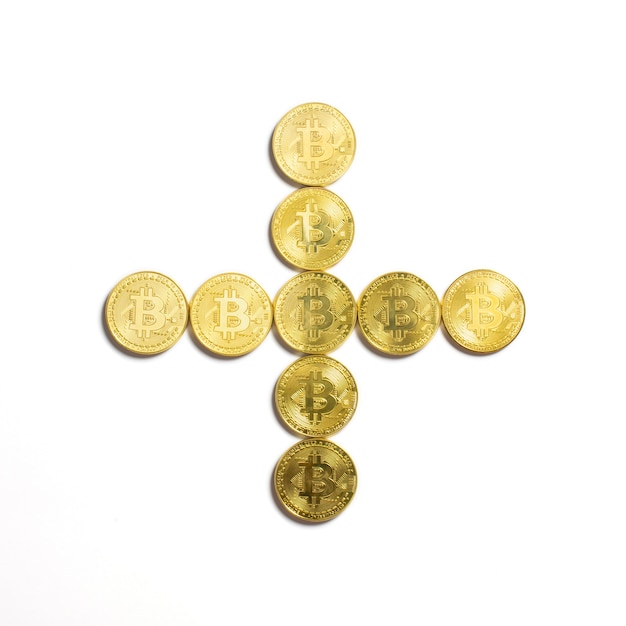 Free photo the plus symbol laid out of bitcoin coins and isolated on white background