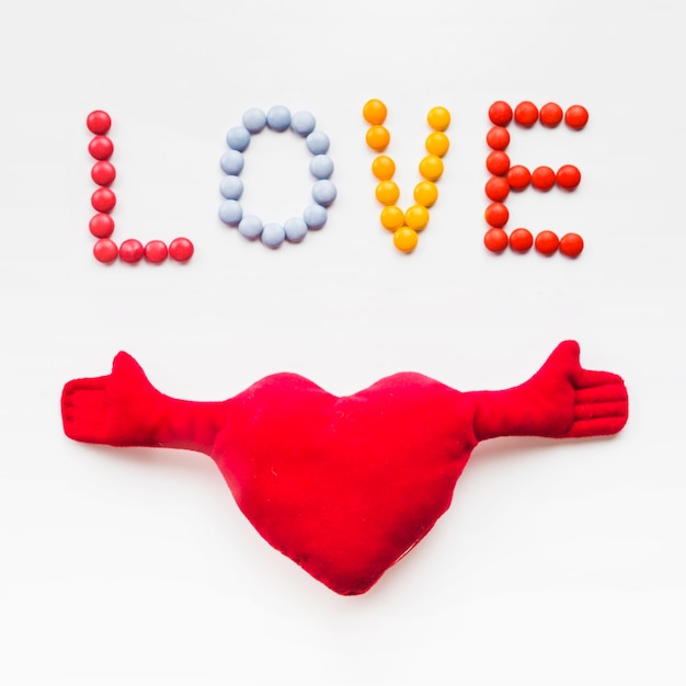 Free photo plush heart near love writing