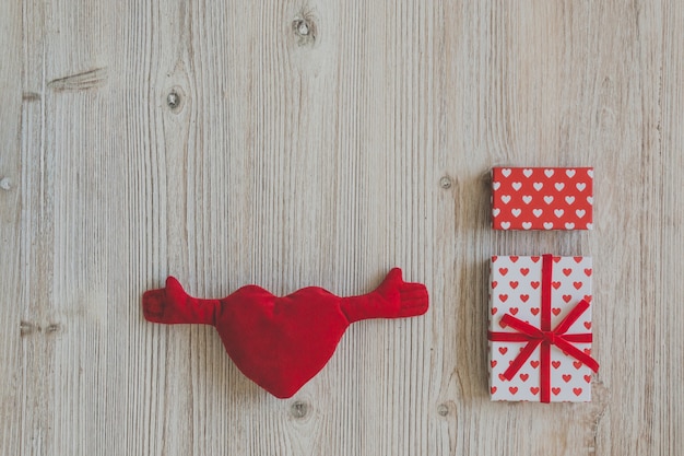 Plush heart with arms and hands and gift boxes