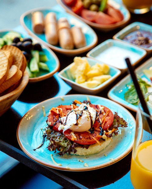 Free photo poached eggs on tomato and crispy bread on a plate