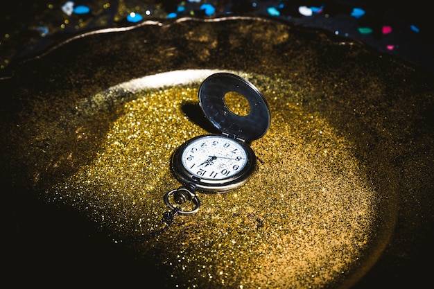 Pocket watch on plate with sequins 