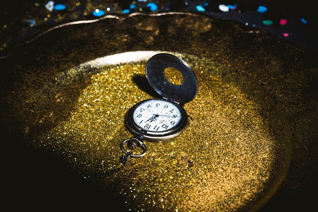 Pocket watch on plate with sequins 