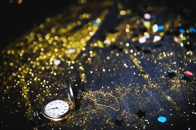 Pocket watch with sequins on table 