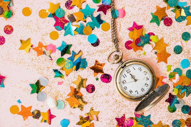 Free photo pocket watch with spangles on table