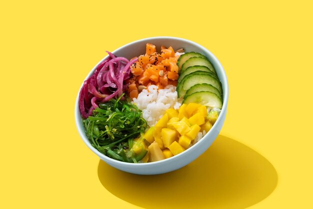 Free photo poke bowl with rice, salmon,cucumber,mango,onion,wakame salad poppy seeds ands sunflowers seeds