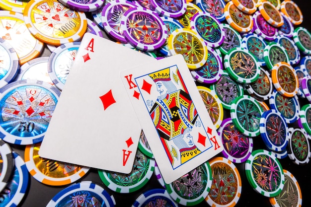 Poker chips and cards on black background