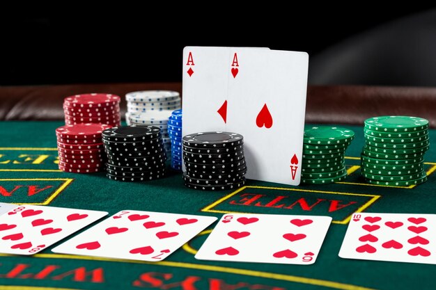 Poker play. Chips and cards on the green table