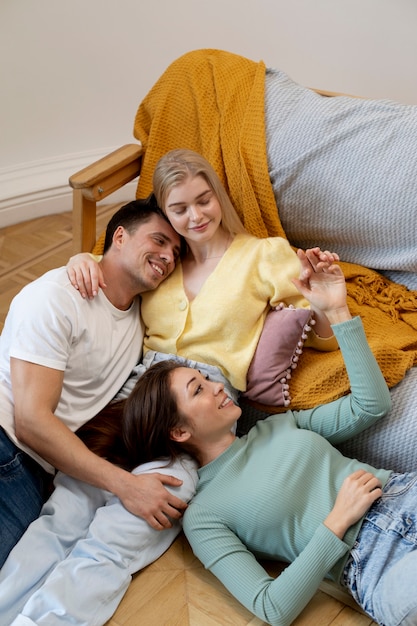 Polyamorous triad on floor medium shot