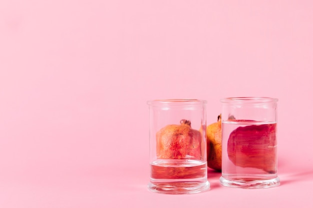 Pomegranate behind glasses with water