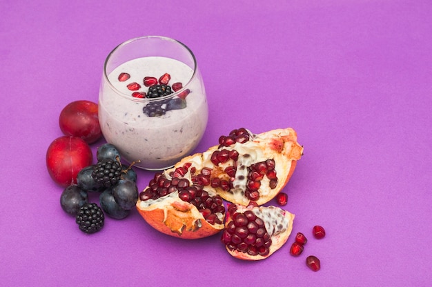 Free photo pomegranate; grapes; plum and blackberries smoothies on purple background