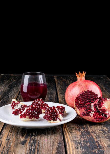 Pomegranate juice and pomegranate on wooden table