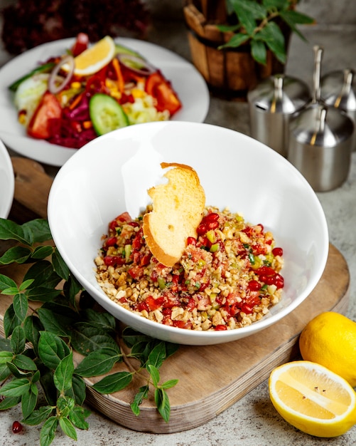 Pomegranate salad with vegetables and topped with cracker