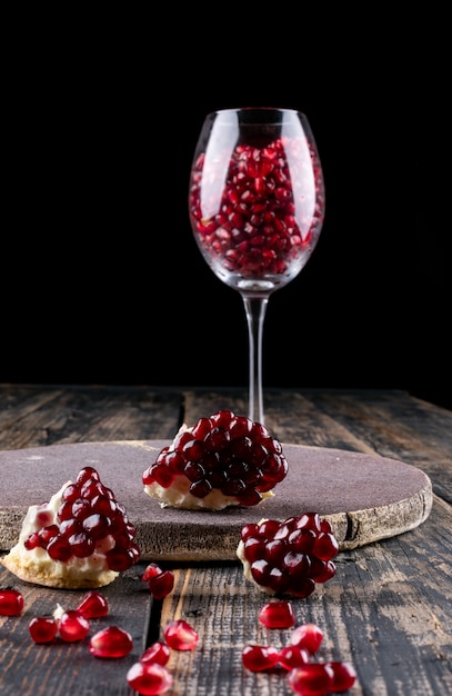 Pomegranate in wine glass on wooden surface