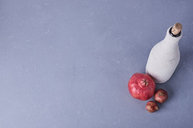 Free photo pomegranates with a bottle of wine,  top view.