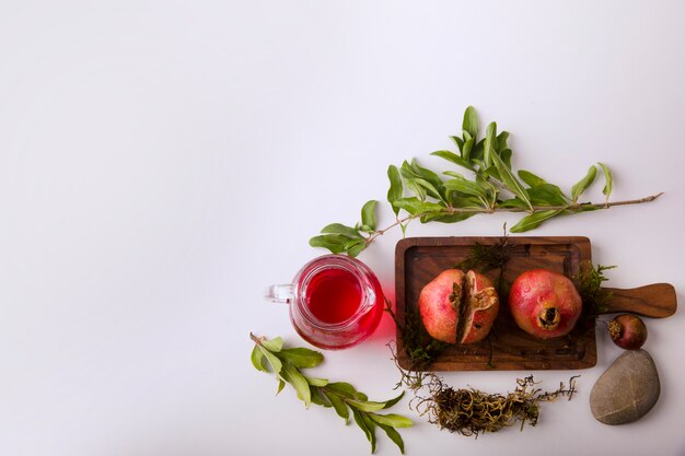 Pomegranates with red sauce and juice on a wooden board, top view