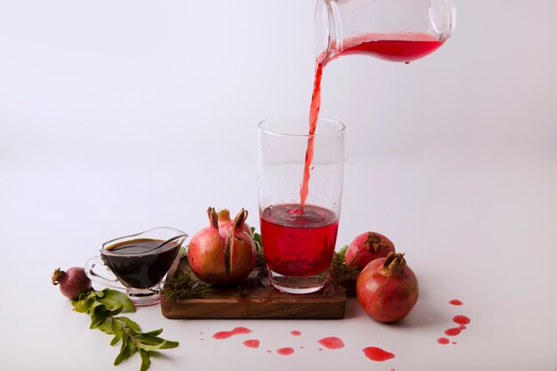 Pomegranates with red sauce and juice on a wooden board