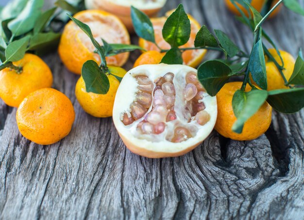 Pomelo pomegranate and tangerine on a wooden table