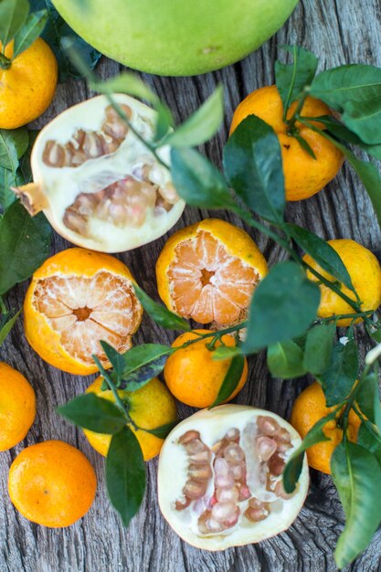 Pomelo pomegranate and tangerine on a wooden table