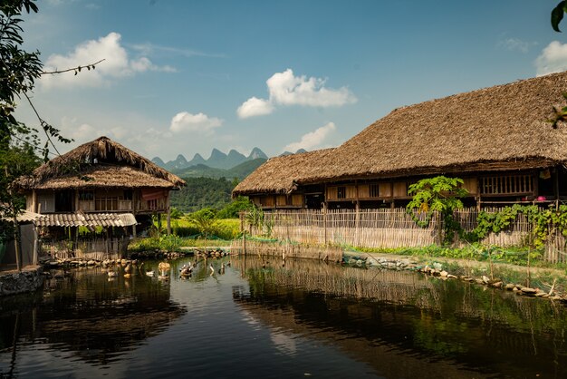 Pong with a wooden village building near it under a blue sky