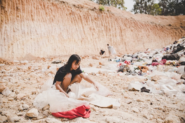 Poor child in the landfill looks forward with hope