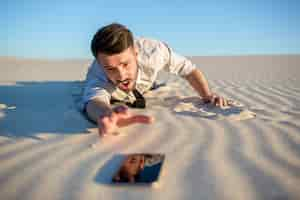 Free photo poor signal. businessman searching for mobile phone signal in desert