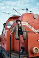 Бесплатное фото Поп-панк эстетический портрет женщины, позирующей у локомотива