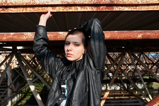 Pop punk aesthetic portrait of woman posing on metal structure