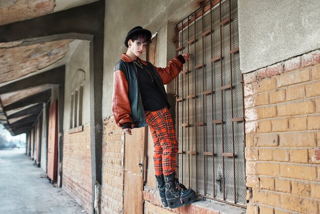 Pop punk aesthetic portrait of woman posing in train station