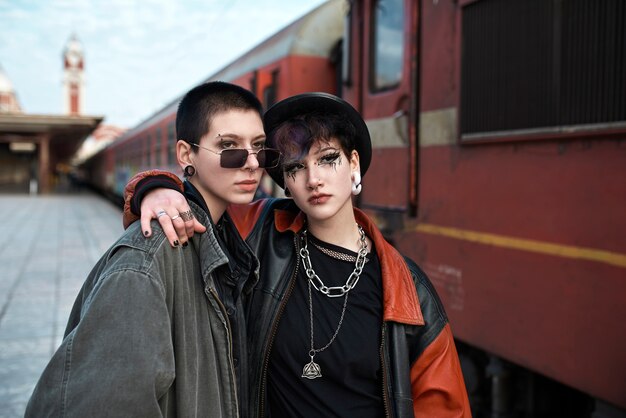 Pop punk aesthetic portrait of women posing by a locomotive