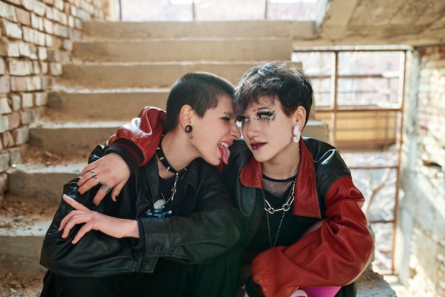 Pop punk aesthetic portrait of women posing inside building on stairs