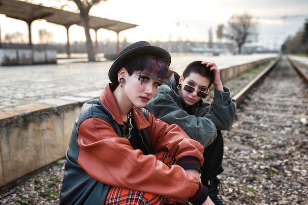 Pop punk aesthetic portrait of women posing on train tracks