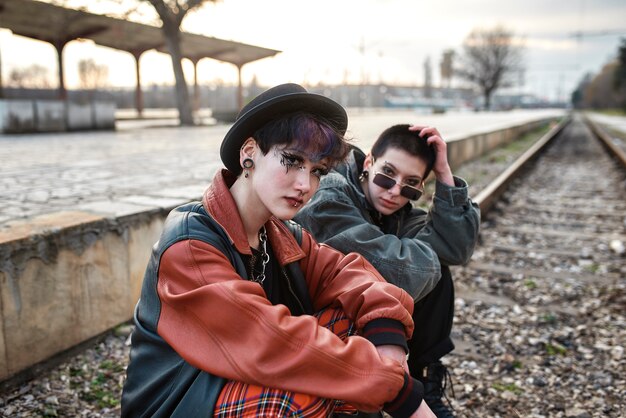 Pop punk aesthetic portrait of women posing on train tracks