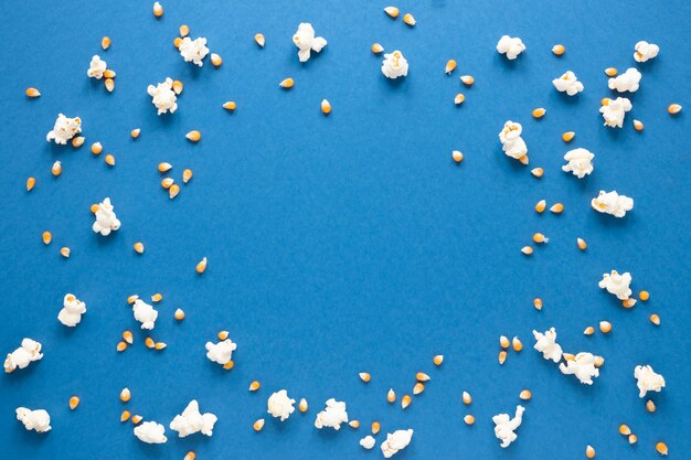 Popcorn on blue background with copy space in center