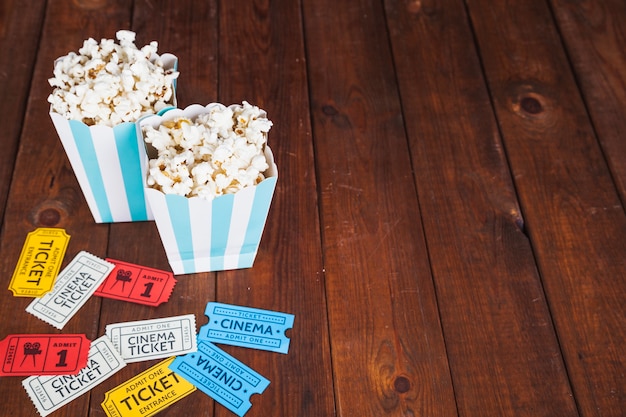 Popcorn boxes and tickets on wooden background