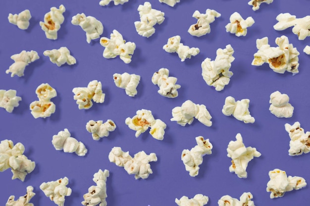 Popcorn on dark purple color background top view