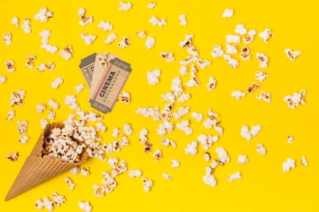 Popcorns spilled from the waffle cone with cinema ticket