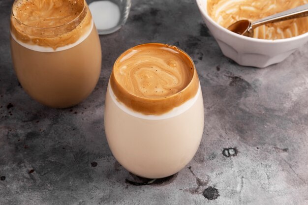 灰色の空間のガラスのインスタントコーヒー 砂糖 お湯 牛乳で作られた人気の飲み物韓国のダーゴンコーヒー プレミアム写真