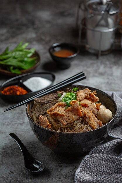 Лапша из свинины, классическая тайская еда, популярные меню и готовые к употреблению супы. В чаше также есть базилик.
