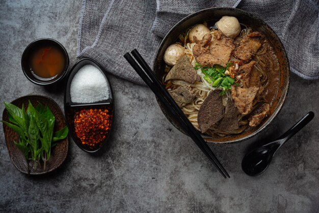 Pork boat noodles, classic Thai food and popular menus and ready to eat soups. There is also a basil in the bowl.