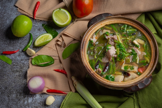 Свиные кости Tom Yum Тайская еда, свиные ребрышки Tom Yum, украшенные ингредиентами.