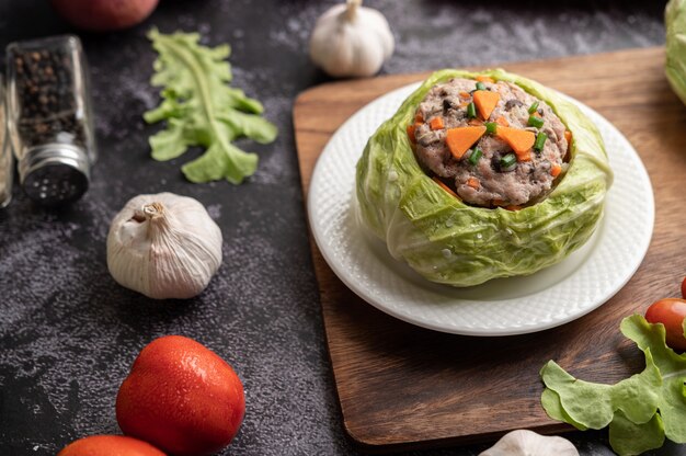 Pork cabbage soup with carrots, chopped green onions, cucumber in a wooden plate on a wooden plate