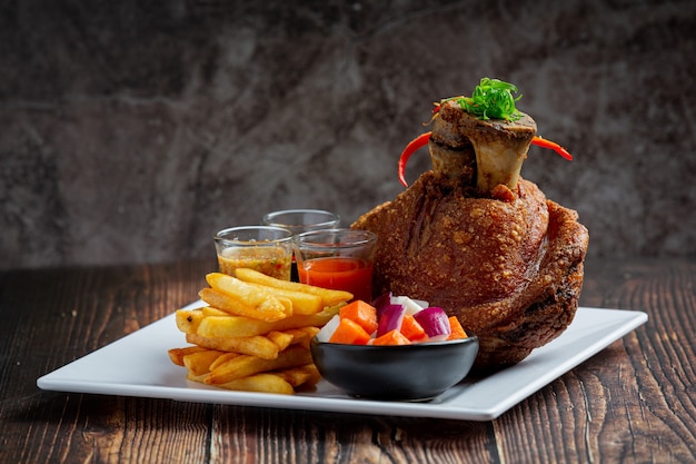 Pork hock in German with sauces on dark background