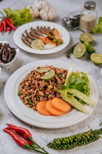 Pork Larb with carrot, cucumber, lime, spring onion, chili, freshly ground pepper, and lettuce.