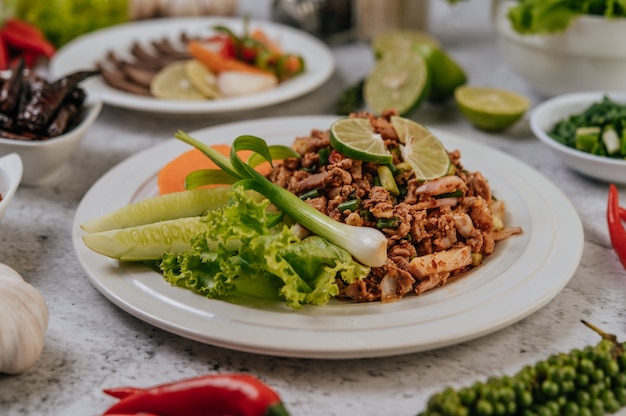 Pork Larb with carrot, cucumber, lime, spring onion, chili, freshly ground pepper, and lettuce.