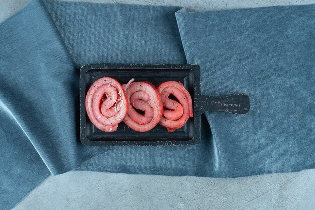 Pork lard on a board on pieces of fabric , on the blue table. 