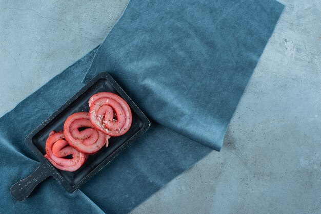 Pork lard on a board on pieces of fabric , on the blue table. 