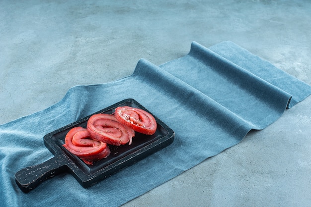 Free photo pork lard on a board on pieces of fabric , on the blue table.