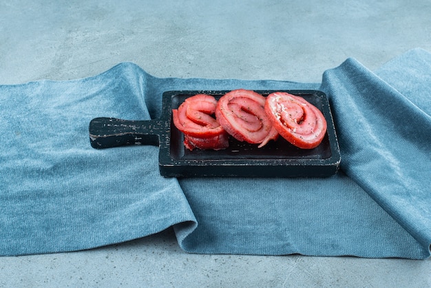 Pork lard on a board on pieces of fabric , on the blue table